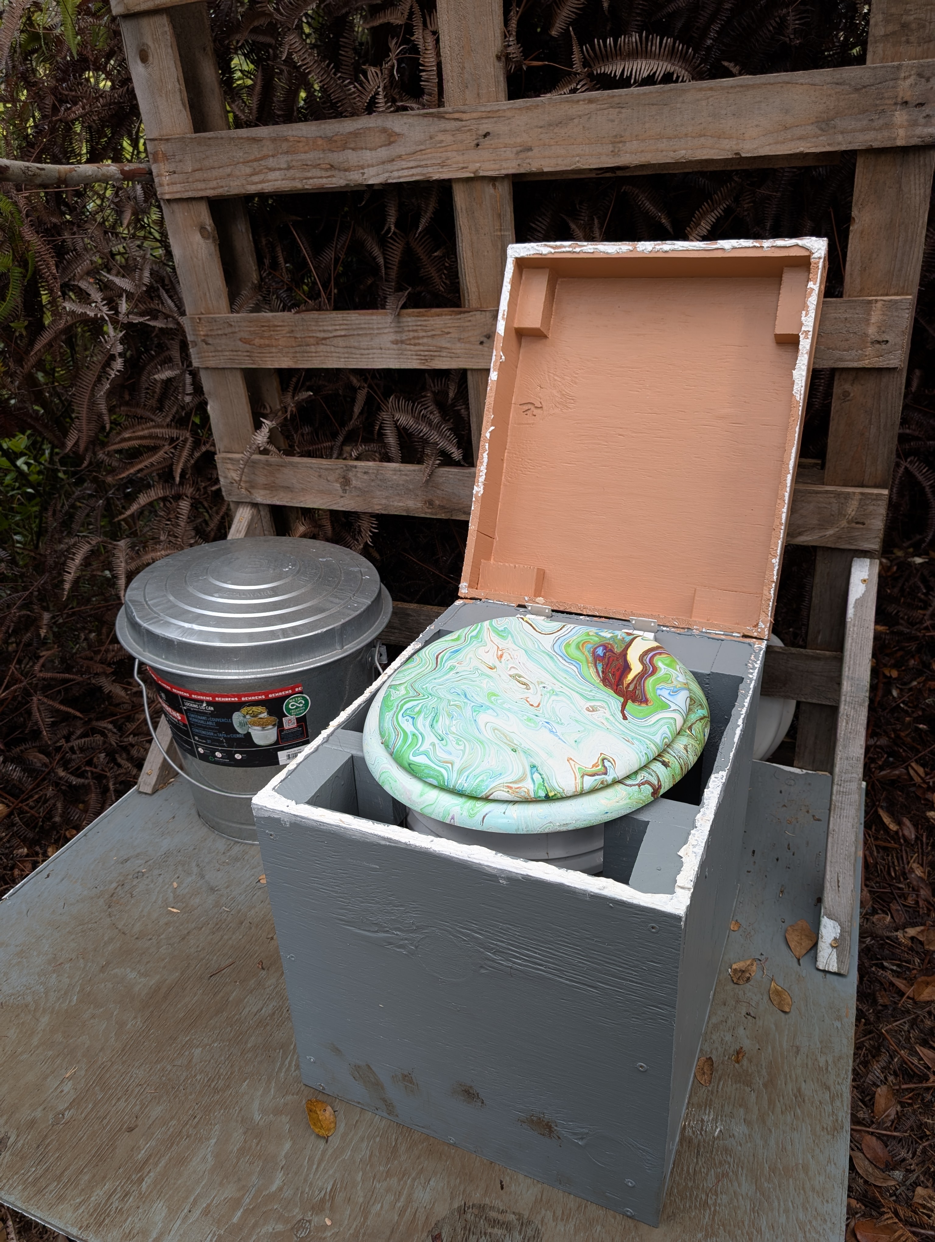Composting toilet with painted seat and sawdust bucket